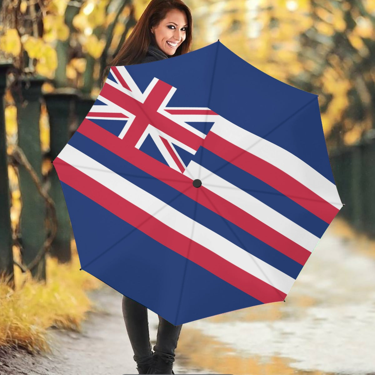 Smiling woman holding [Brand] umbrella with flag design.