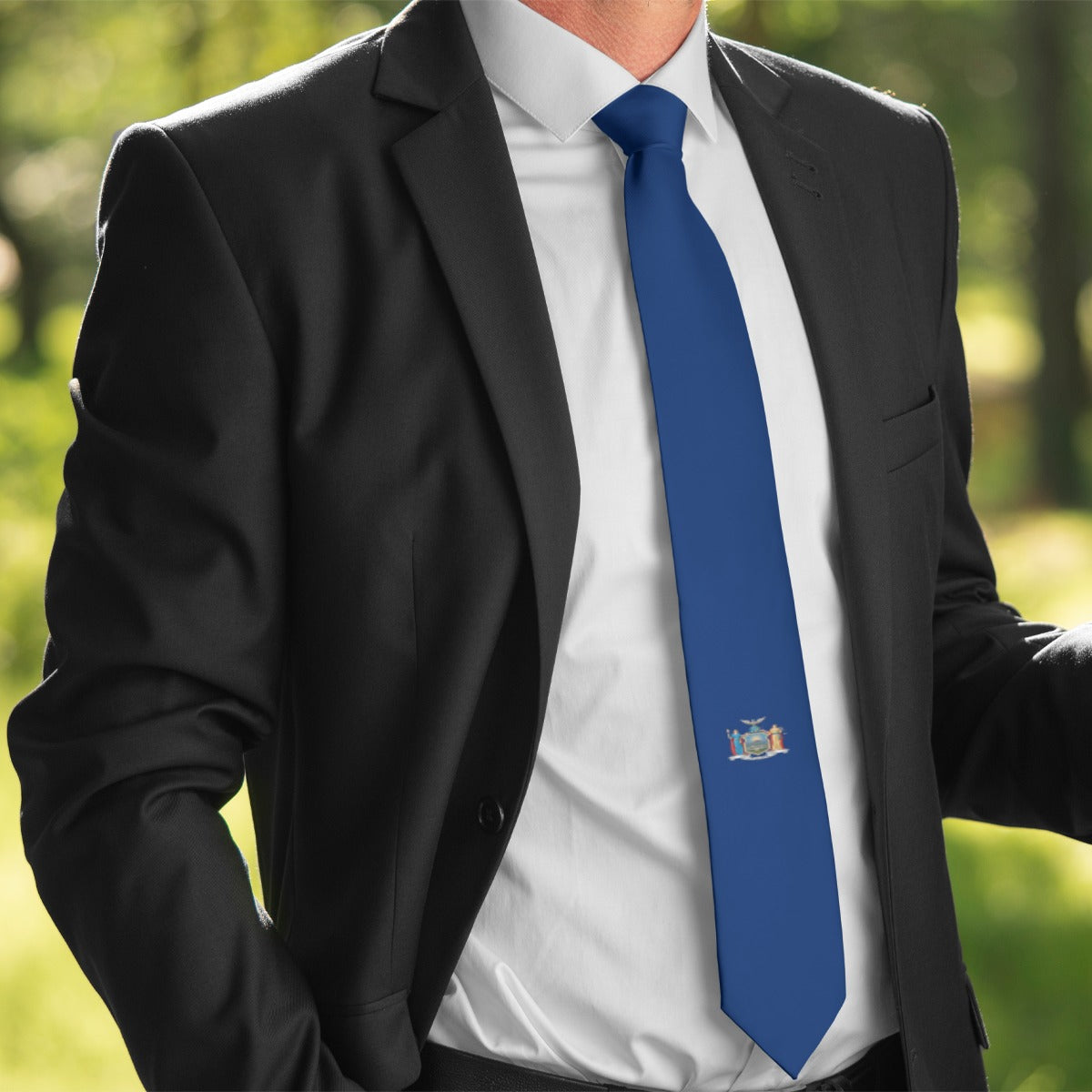 Man in suit wearing [Brand] blue tie with emblem.