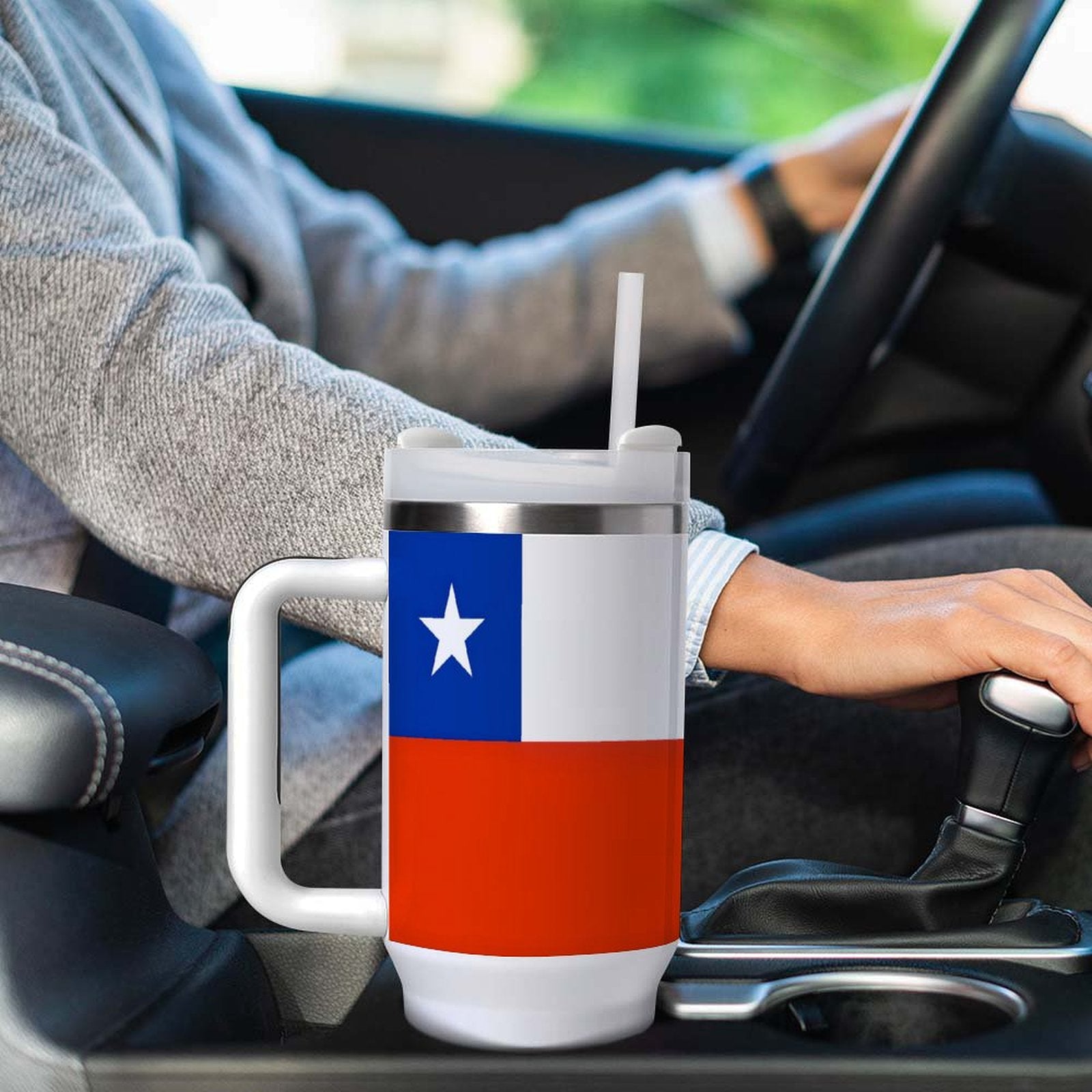 Person driving with [Brand] Texas-themed tumbler in holder.