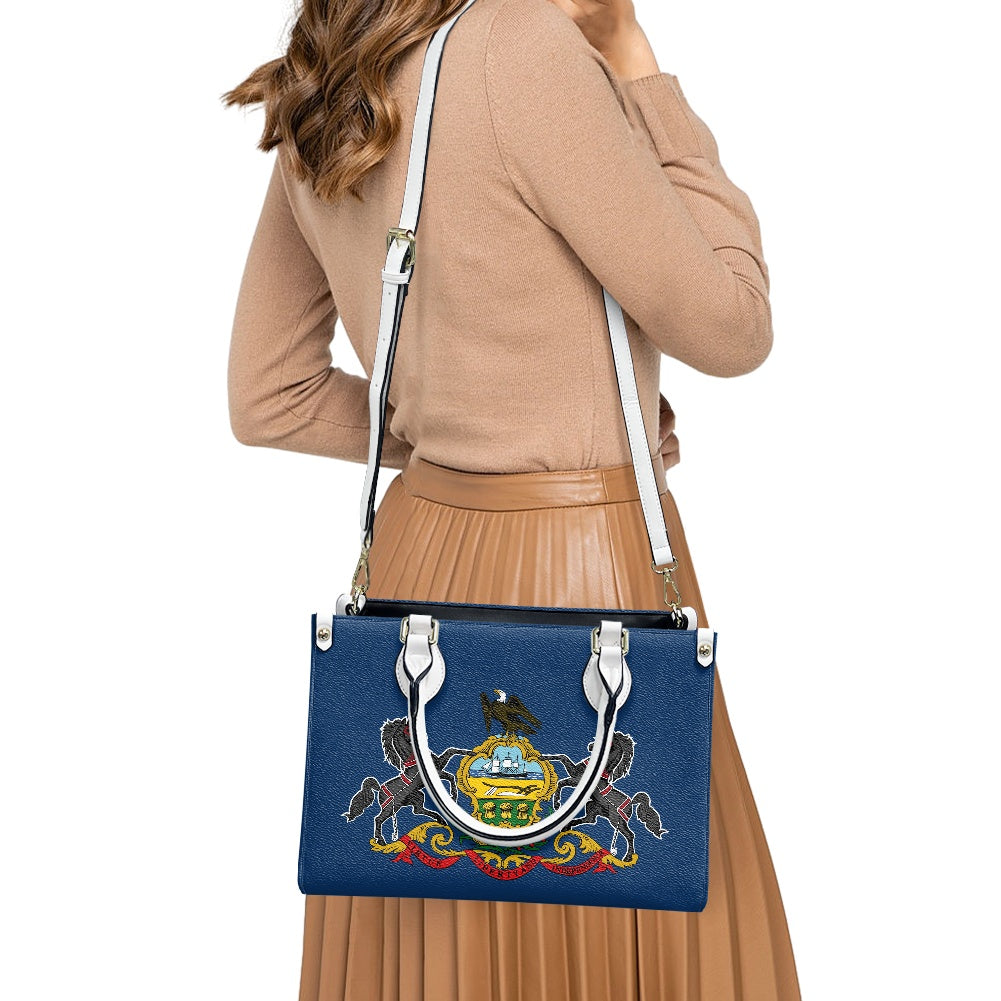 Woman wearing brown outfit carrying [Brand] blue handbag.