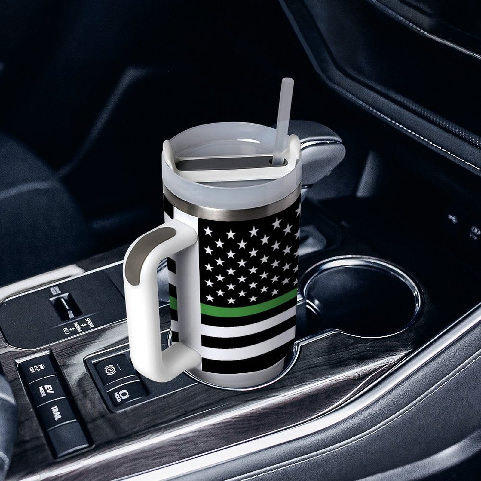 [Brand] travel mug with flag design in car cupholder.