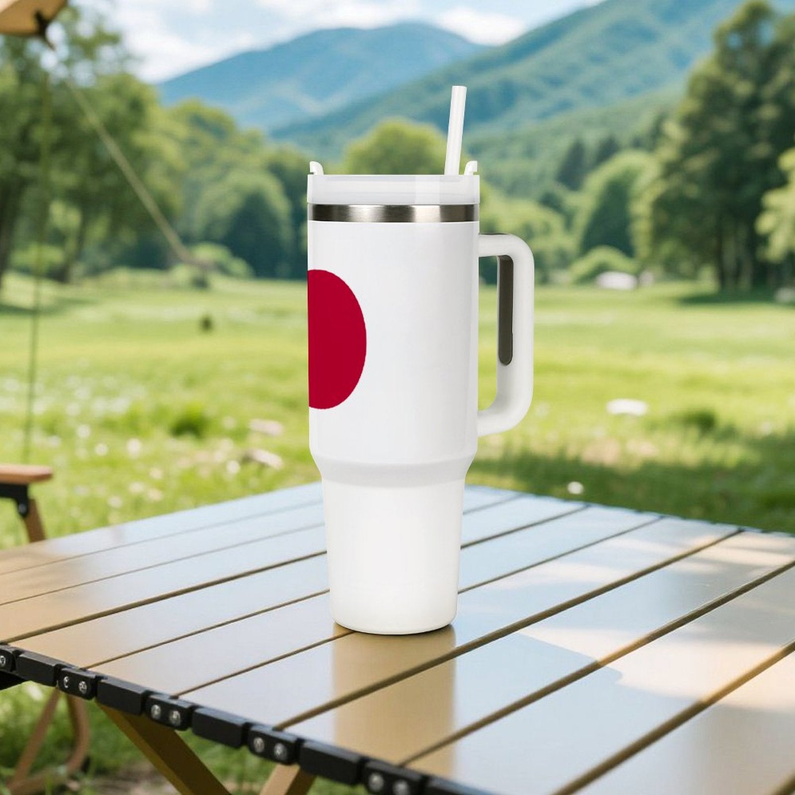 [Brand] tumbler with straw on table, scenic mountain background.