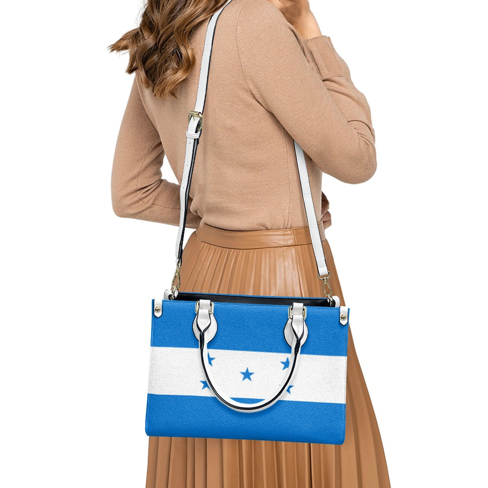 Woman carrying [Brand] bag with blue and white design.