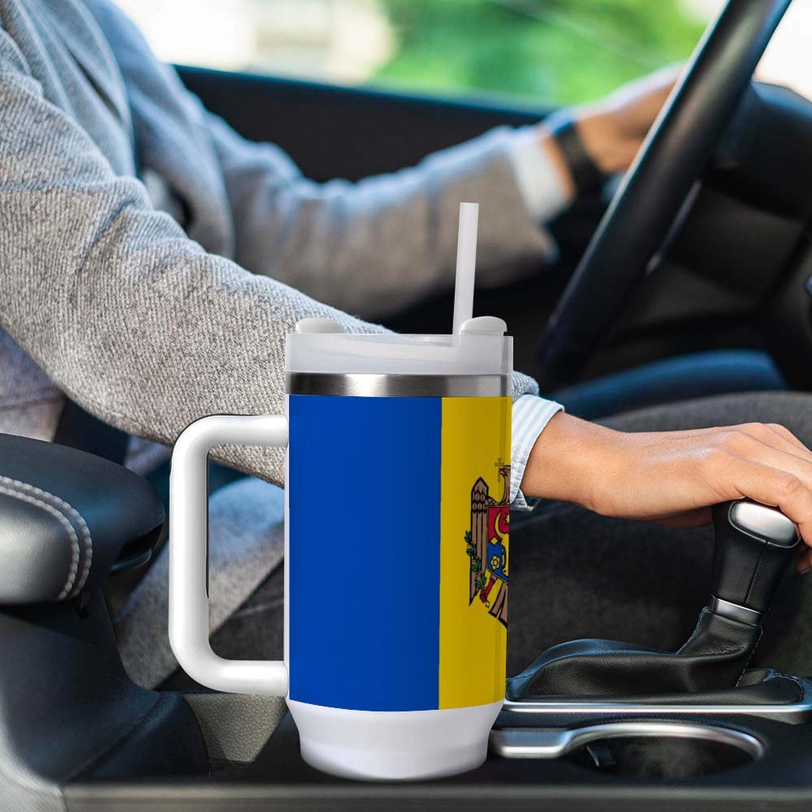 [Brand] travel mug with straw in car cup holder.