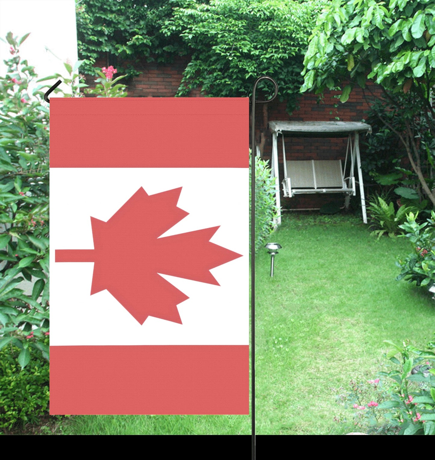 Luv My Flag maple leaf yard flag in garden setting.