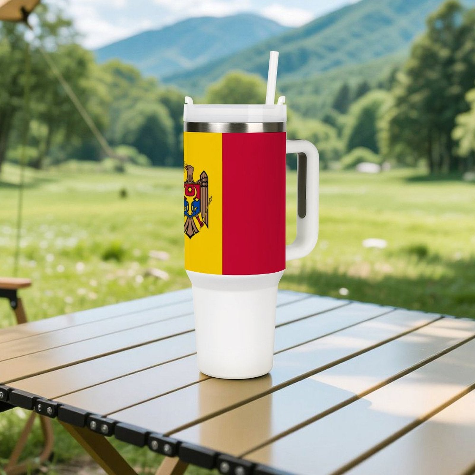 [Brand] travel mug with Moldovan flag on outdoor table.