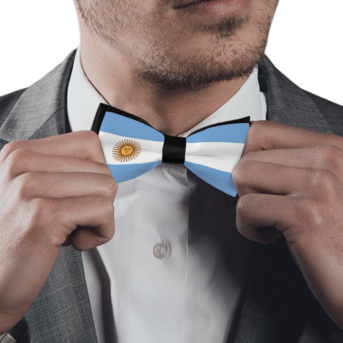 Man adjusting [Brand] Argentine flag bow tie, wearing suit.