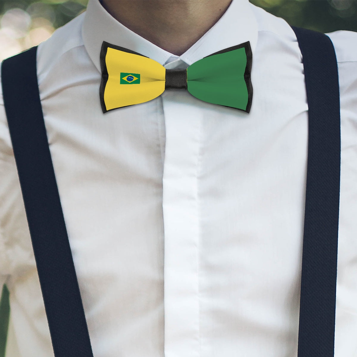 Man wearing [Brand] Brazil-themed bow tie and suspenders, outdoors.