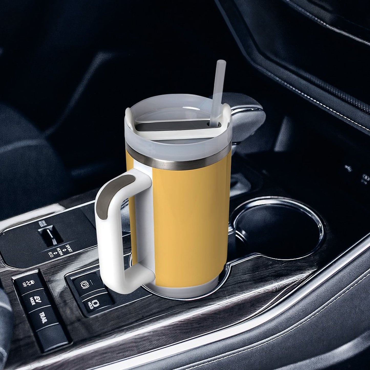 Yellow [Brand] travel mug with straw in car cup holder.
