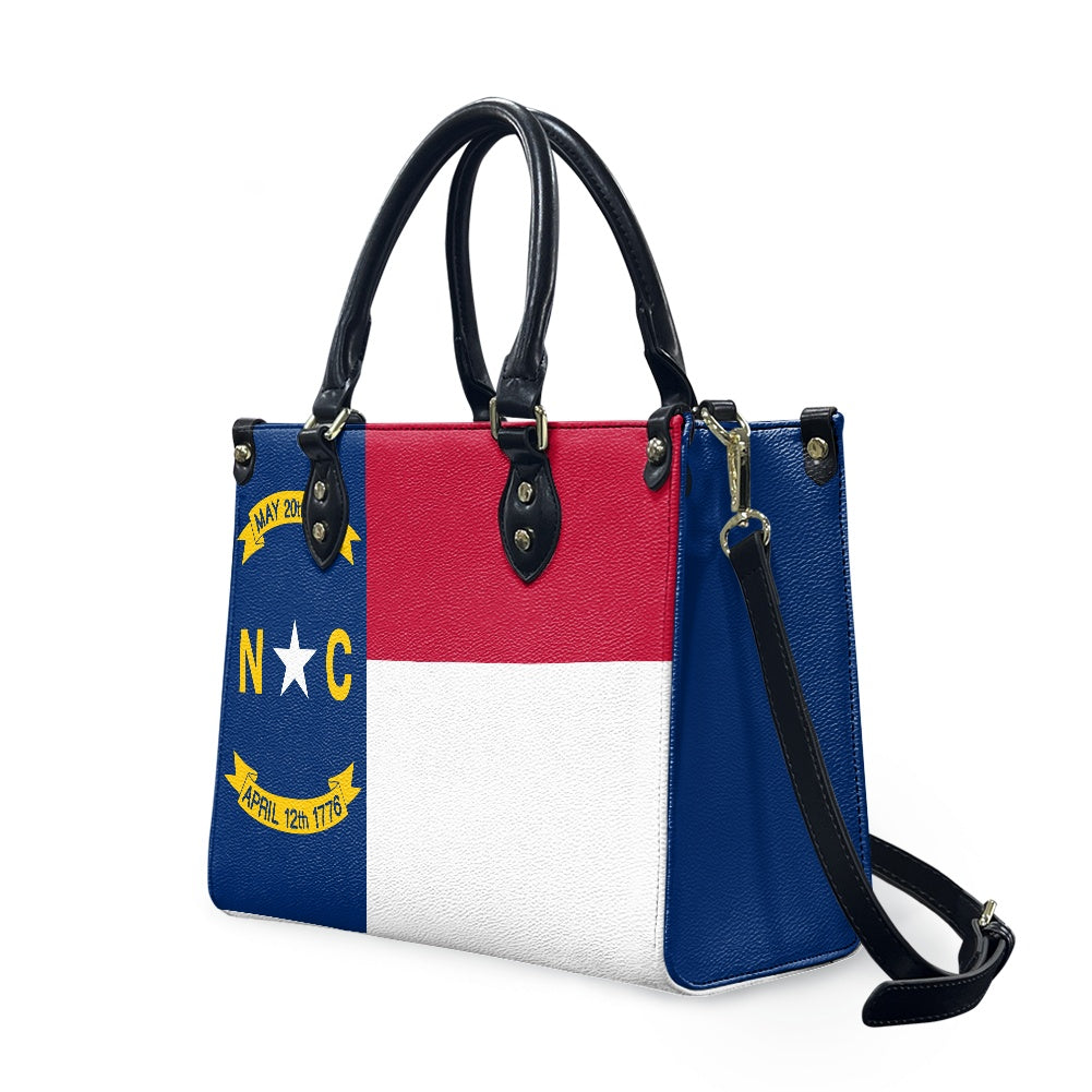 [Brand] handbag featuring North Carolina flag design, black handles.