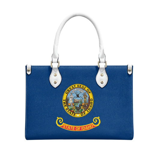Blue handbag featuring Idaho state seal, white handles, [Brand].