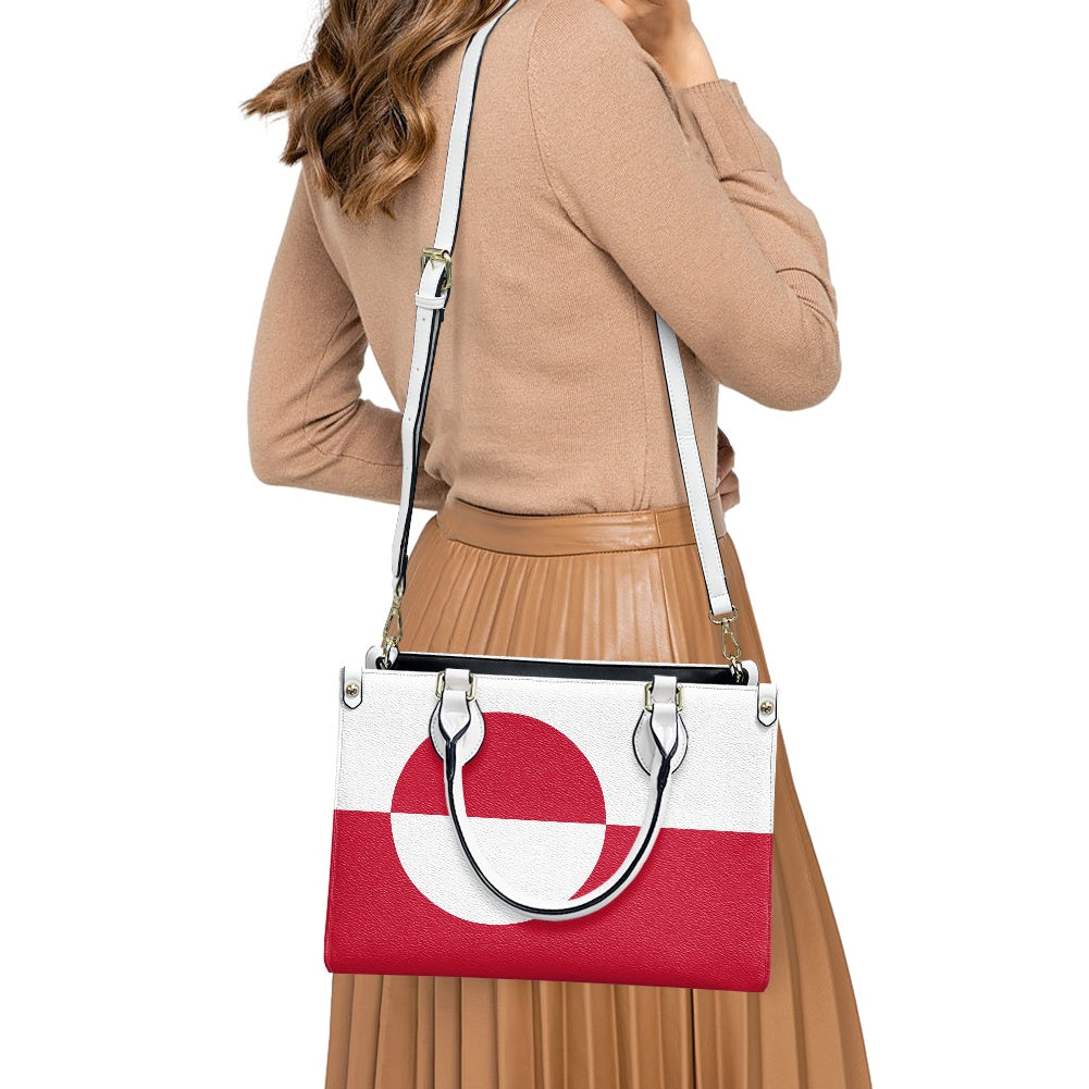 Woman carrying [Brand] handbag with red and white design.
