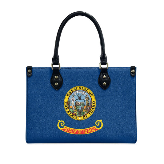 Blue handbag with Idaho state seal, black handles, [Brand].