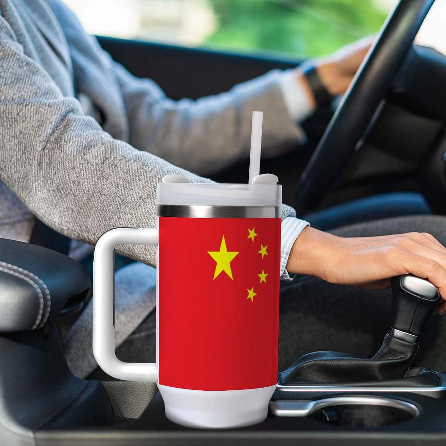 Driver holding [Brand] mug with Chinese flag design.