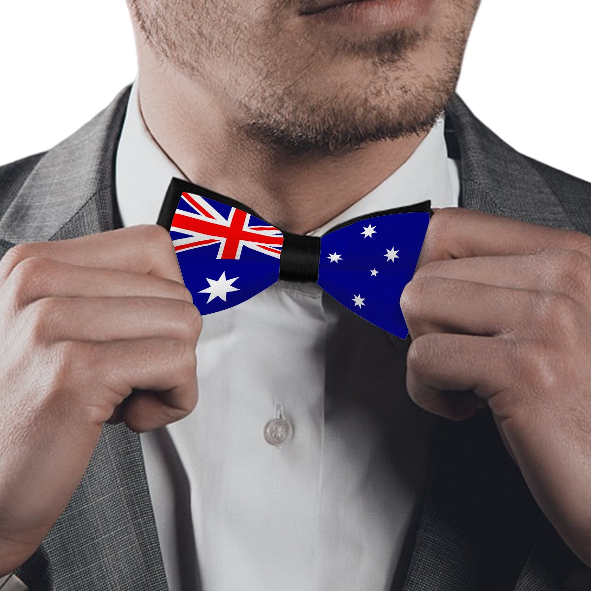 Man adjusts Australian flag bow tie; wearing [Brand] suit.