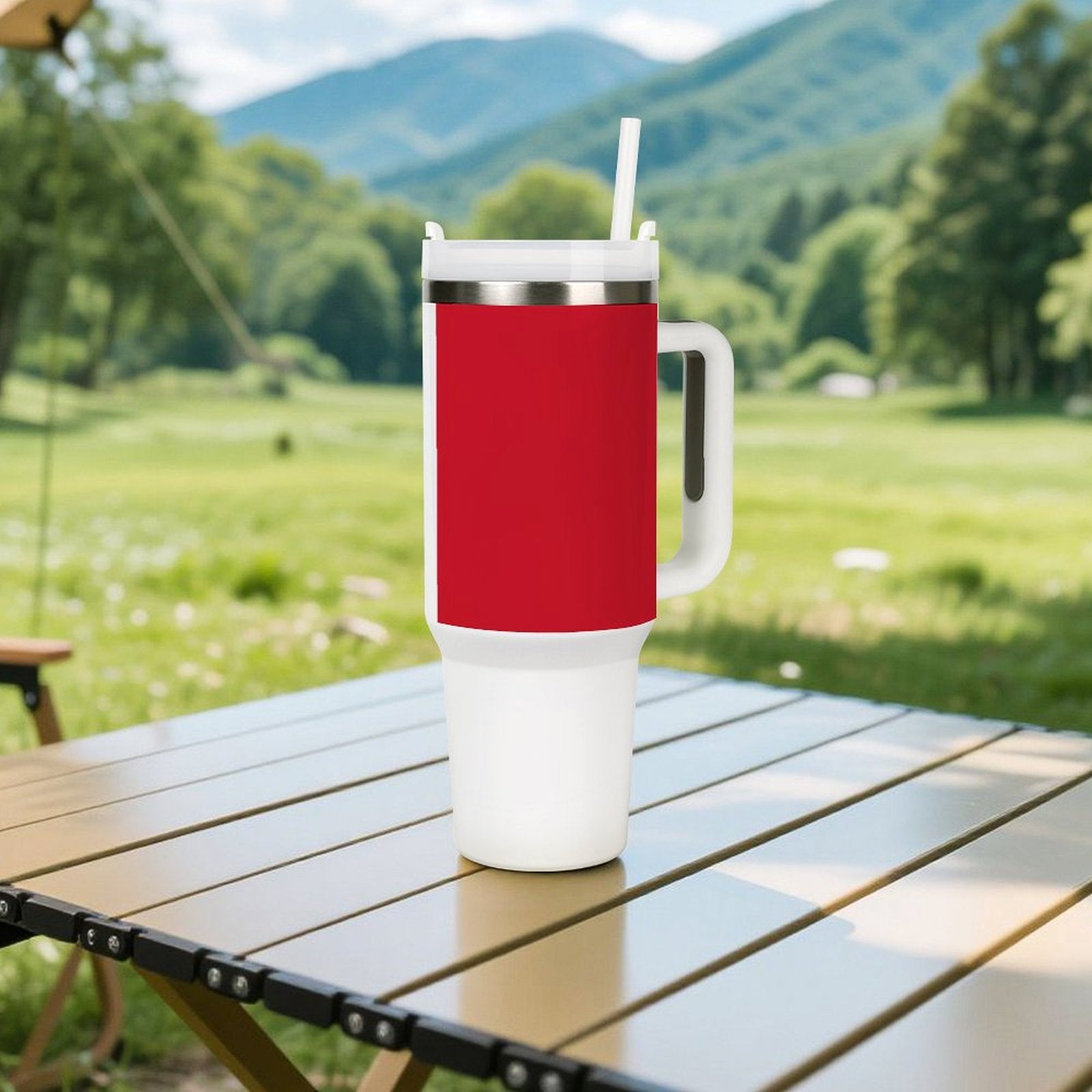 Red and white [Brand] tumbler with straw outside on table.