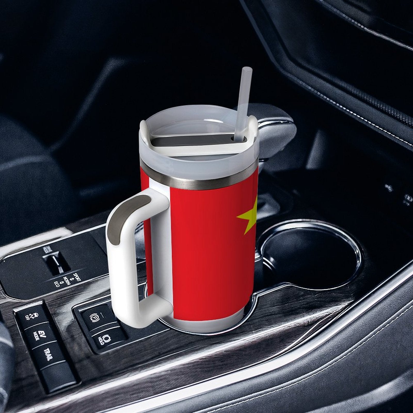 [Brand] red travel mug in car cup holder with straw.