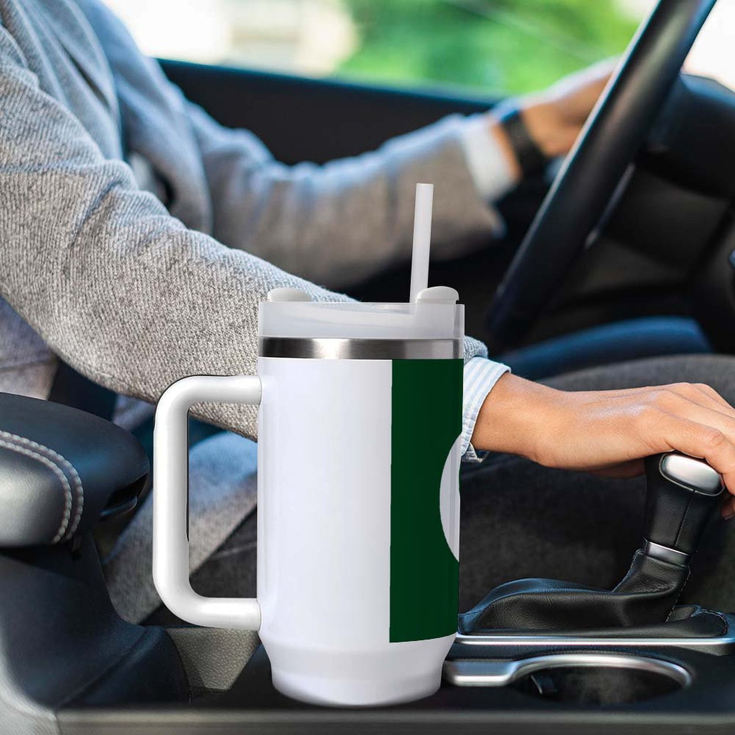 Driving with [Brand] mug in car cup holder, hand visible.