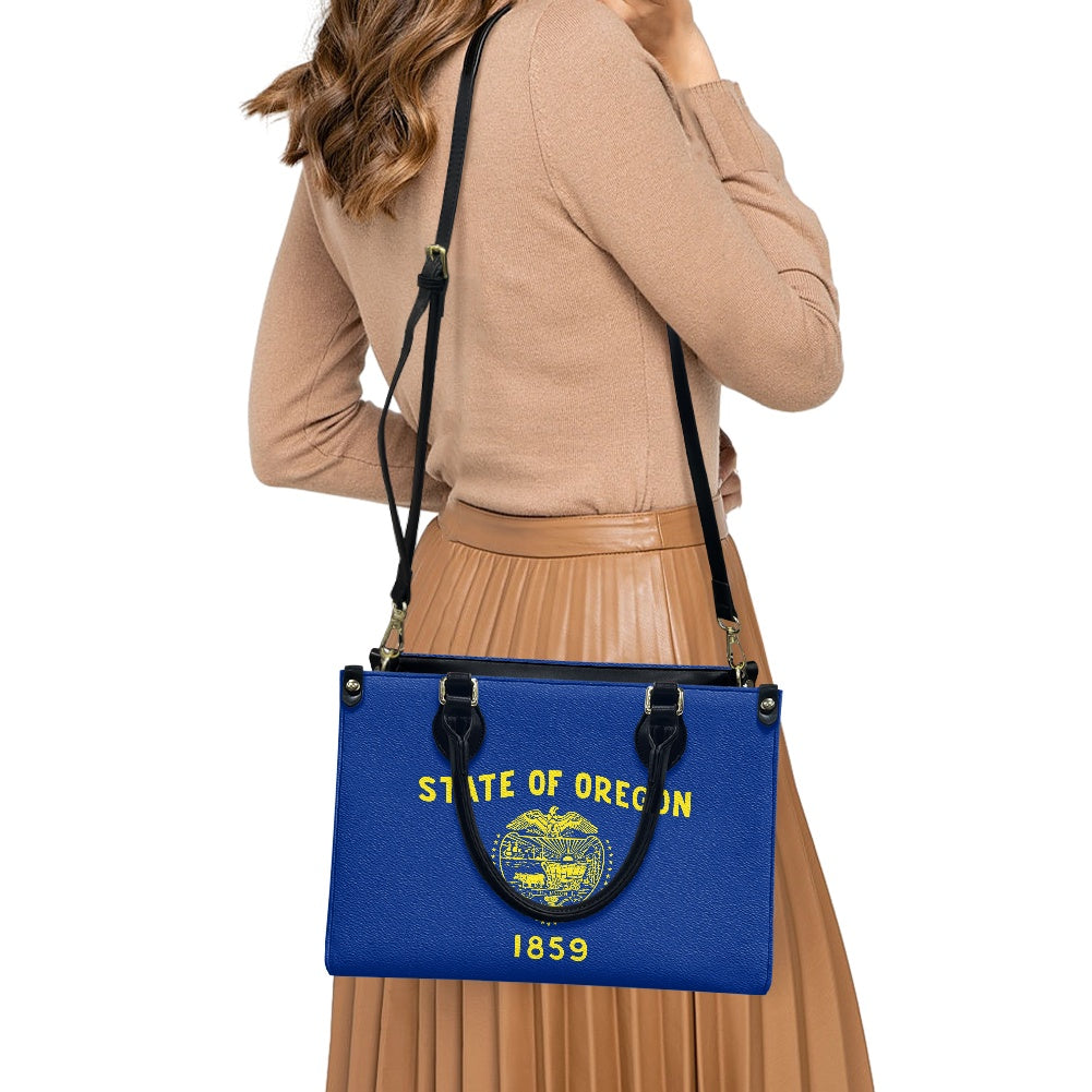 Woman holding blue [Brand] bag with Oregon state design.