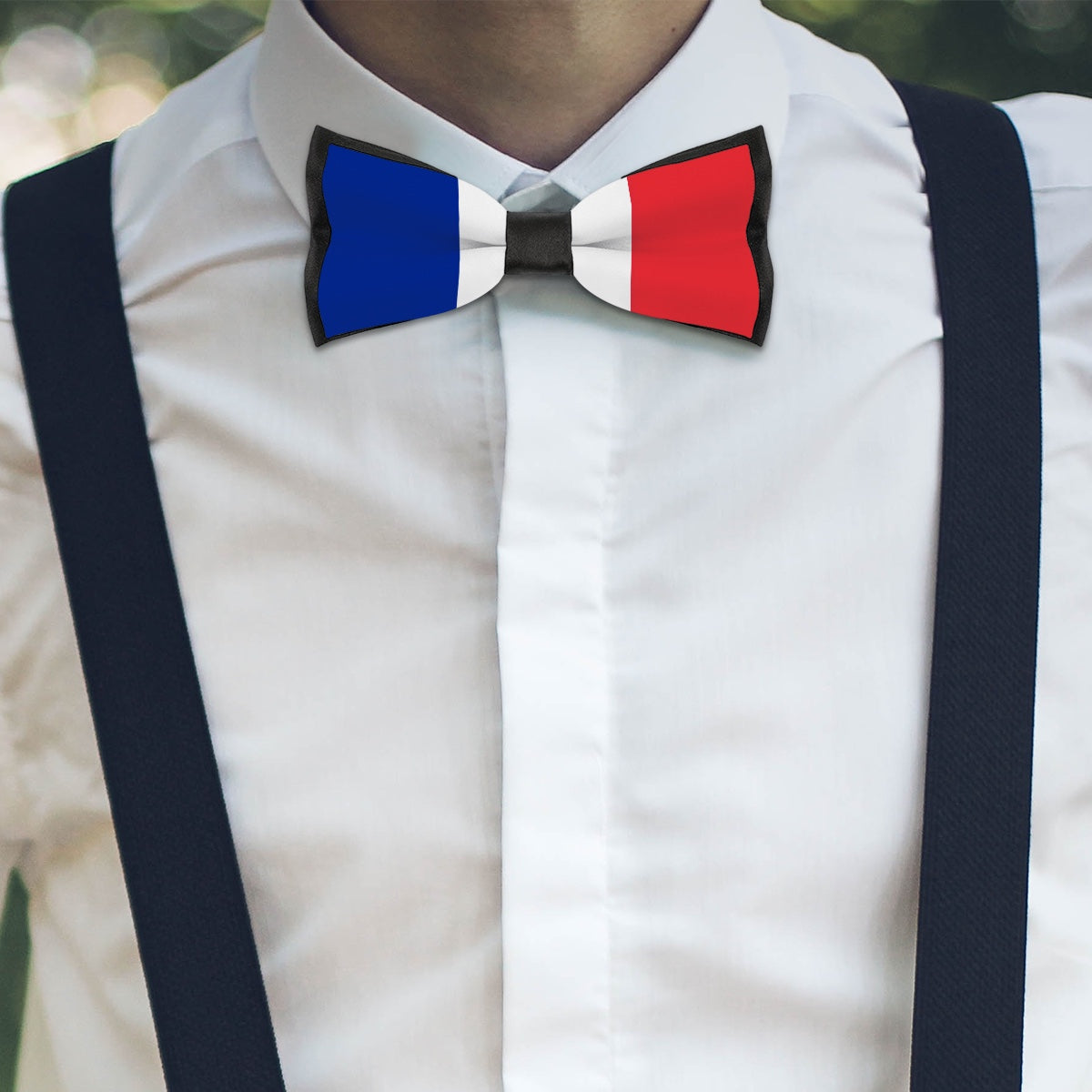Man wearing [Brand] bowtie in French flag colors, suspenders.