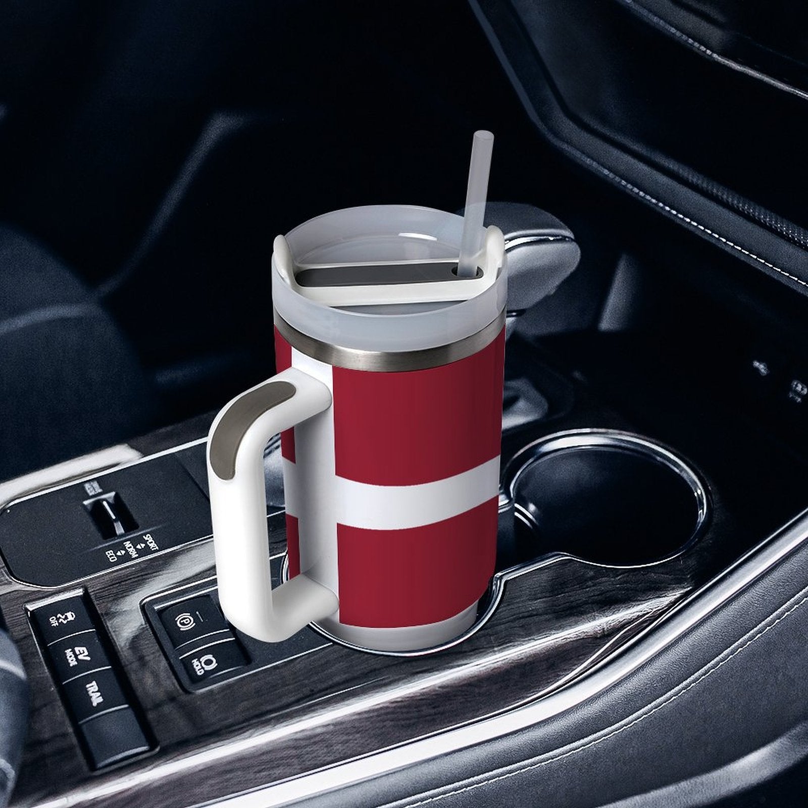 [Brand] travel mug with straw in car's cup holder.