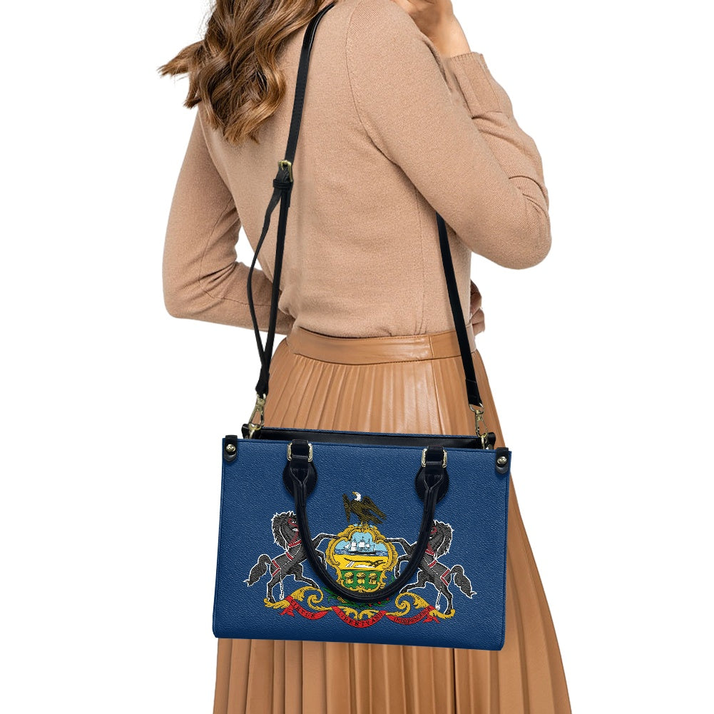 Woman wearing [Brand] bag with Pennsylvania state seal design.
