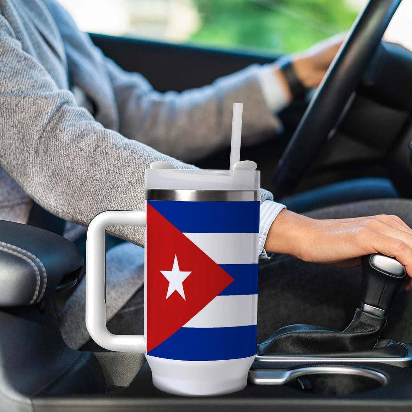 Person driving car with [Brand] mug featuring Cuban flag.