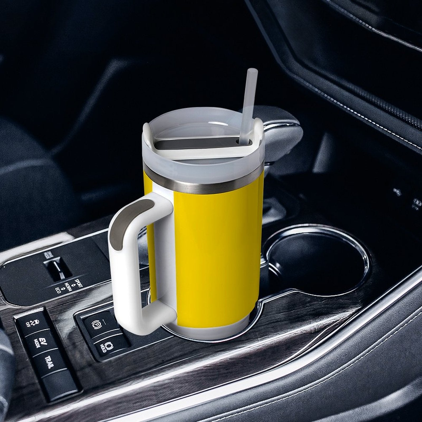Yellow [Brand] mug with handle in car cup holder.