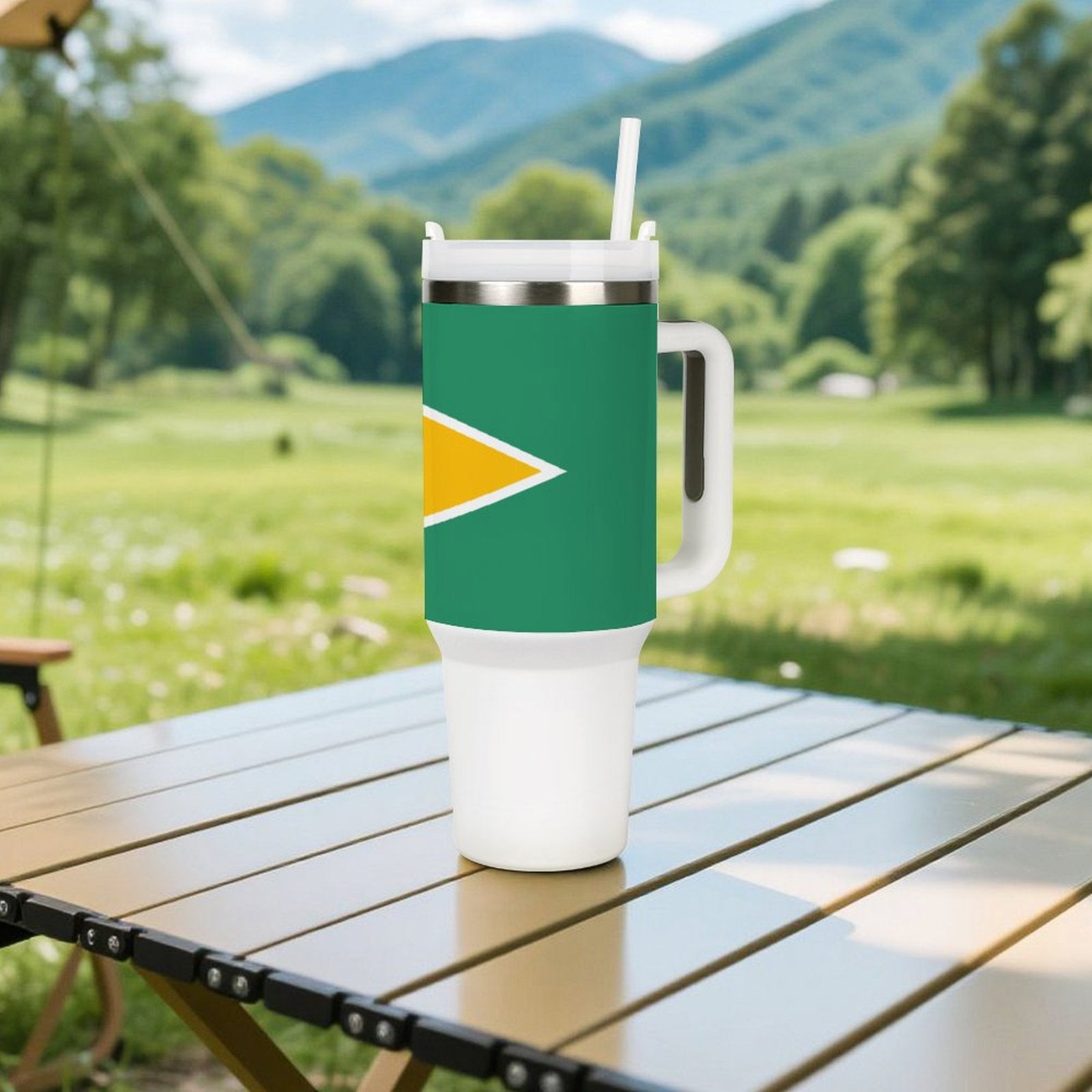 [Brand] tumbler on outdoor table with scenic mountain backdrop.