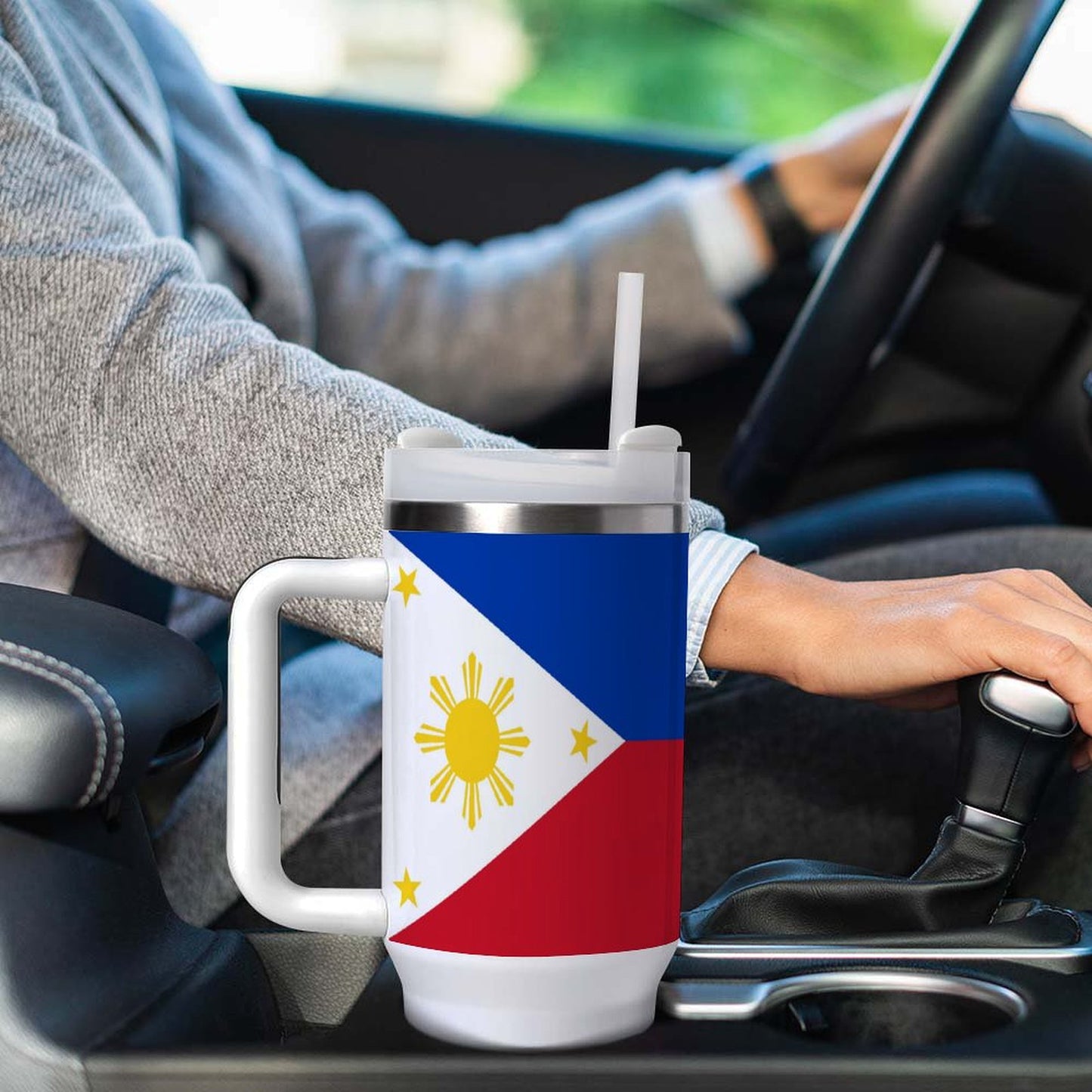 Driver holding [Brand] mug featuring Philippine flag design.