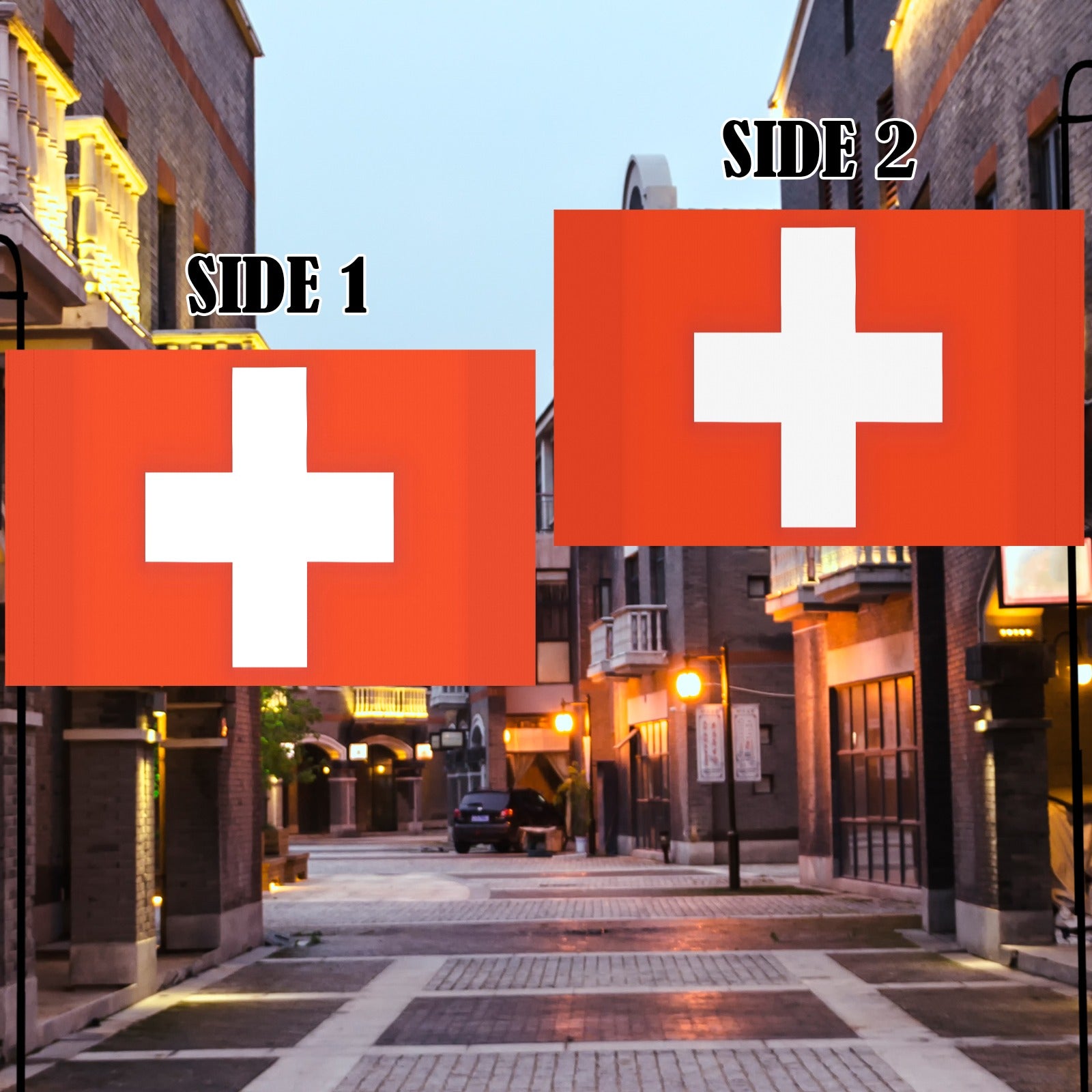 Two Swiss flags by Luv My Flag, evening street.