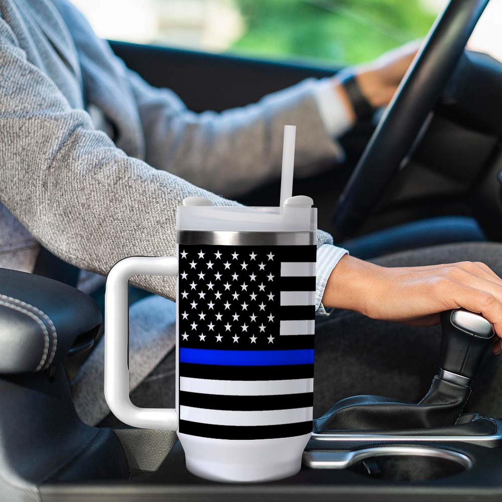 Driver holding gear with [Brand] mug, American flag design.