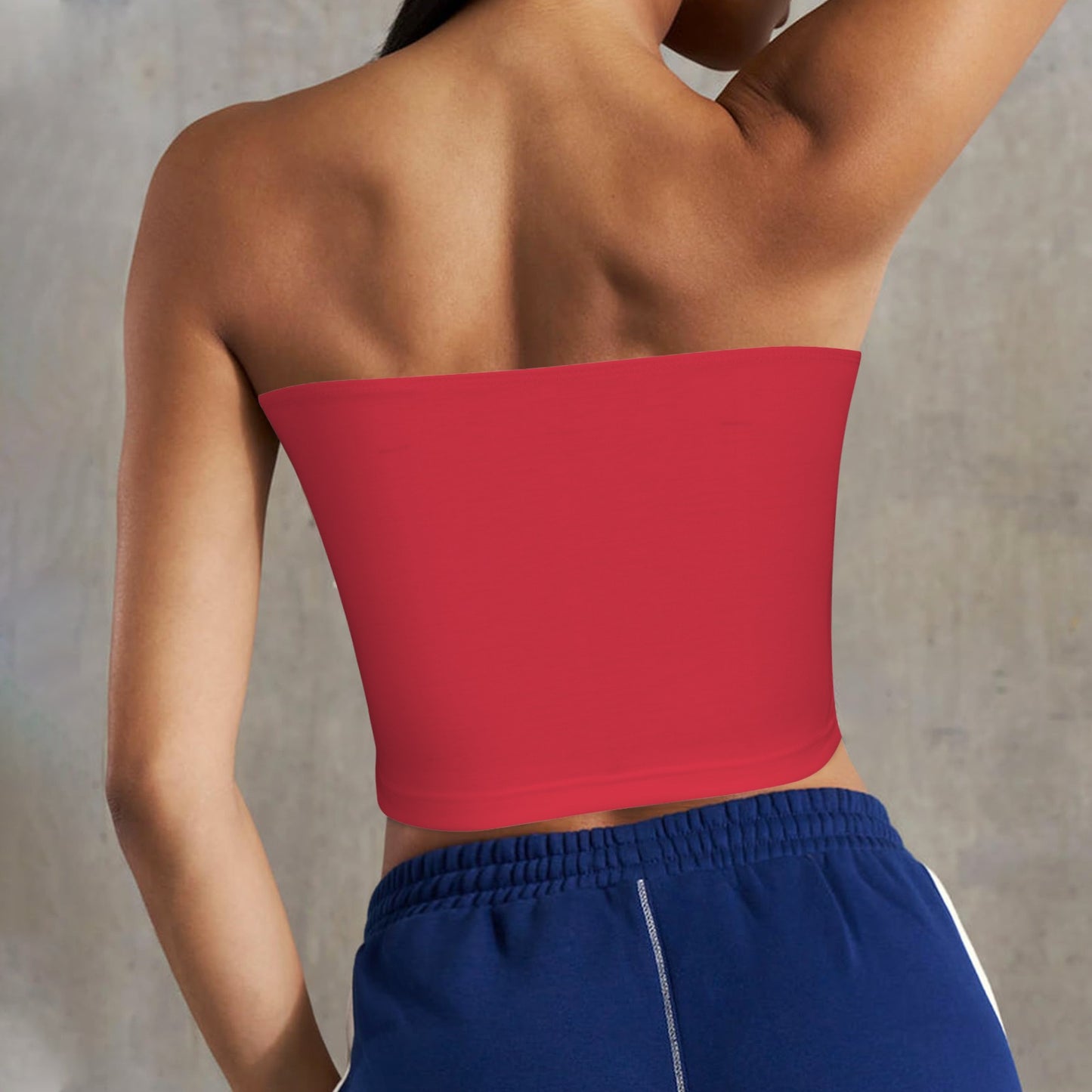 Person wearing a red [Brand] tube top, blue shorts.
