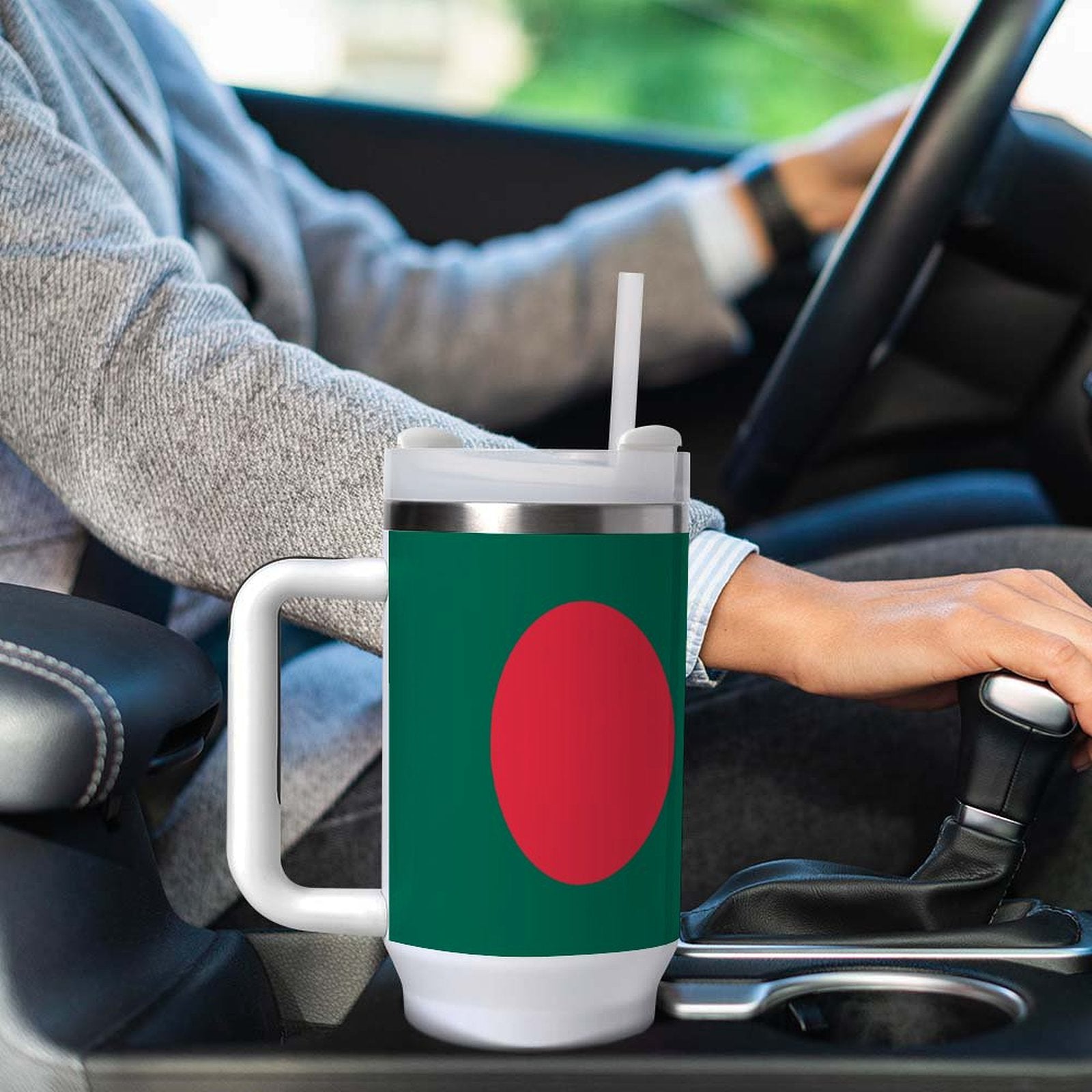 Person driving with [Brand] mug in car cup holder.