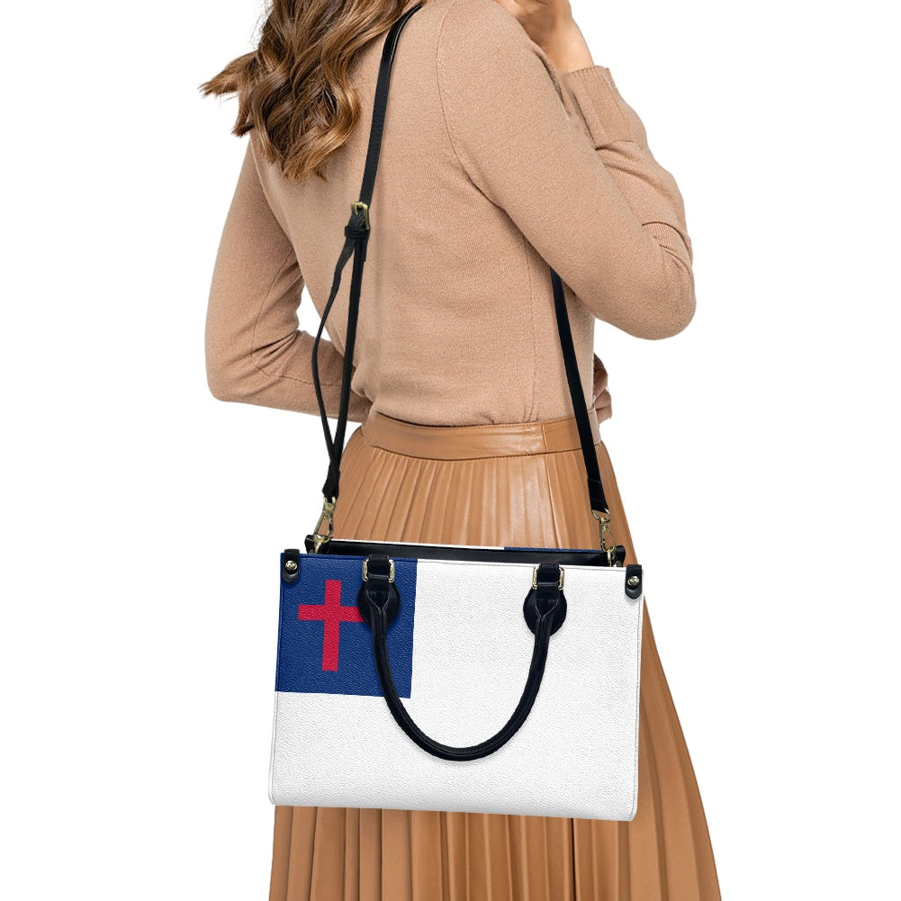 Woman wearing stylish [Brand] handbag with cross design.
