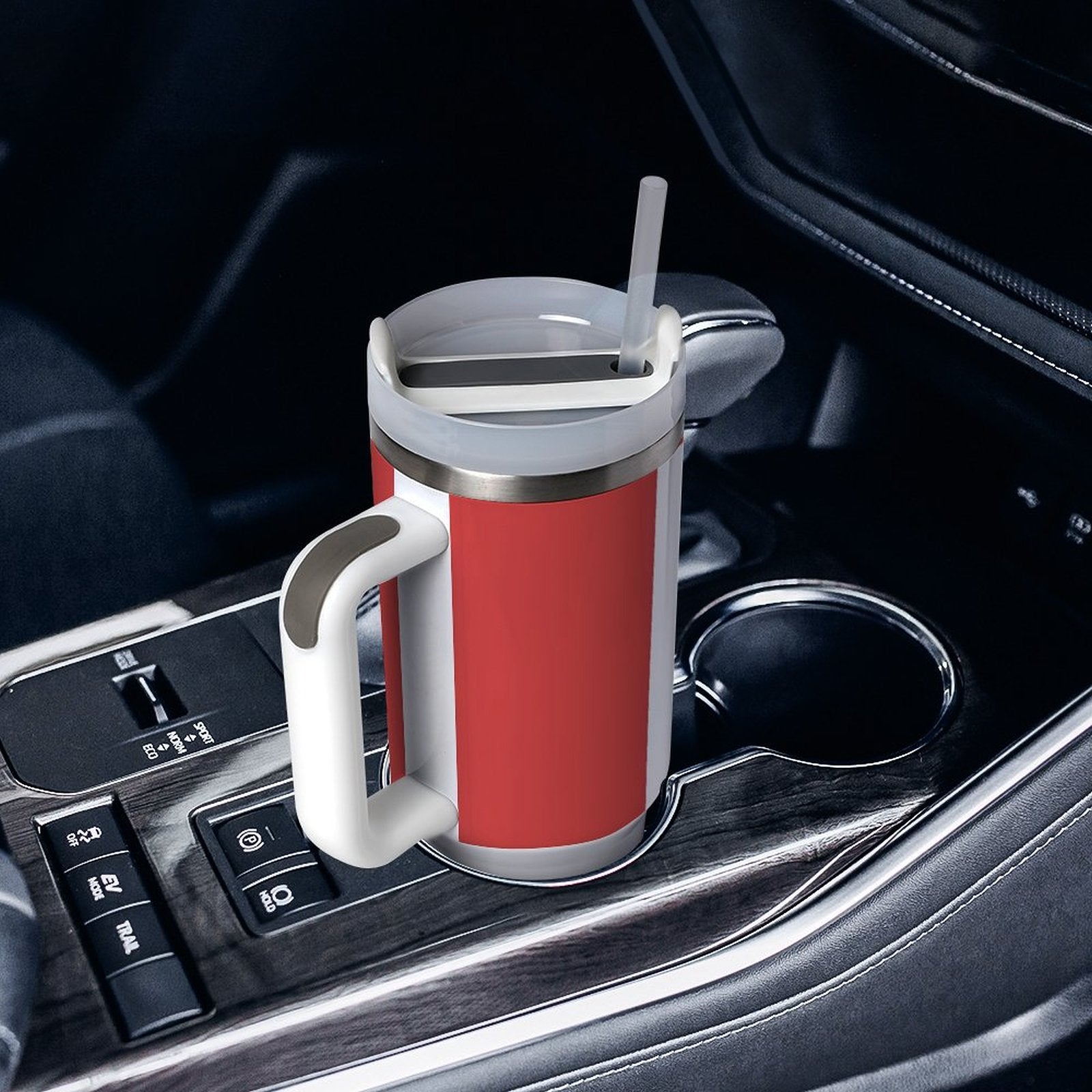 Red and white [Brand] travel mug in car cup holder.