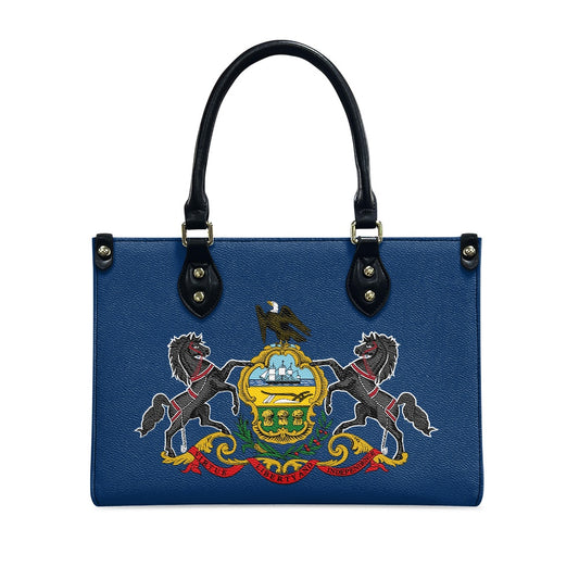 Blue [Brand] handbag featuring a detailed embroidered heraldic design.