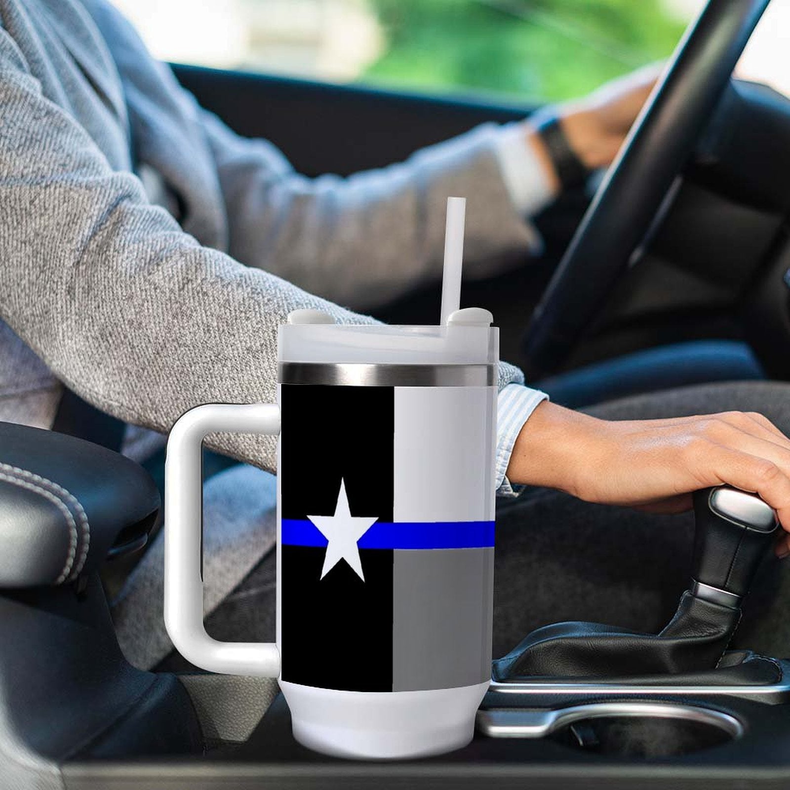 Driver holding gear shift with [Brand] cup in holder.