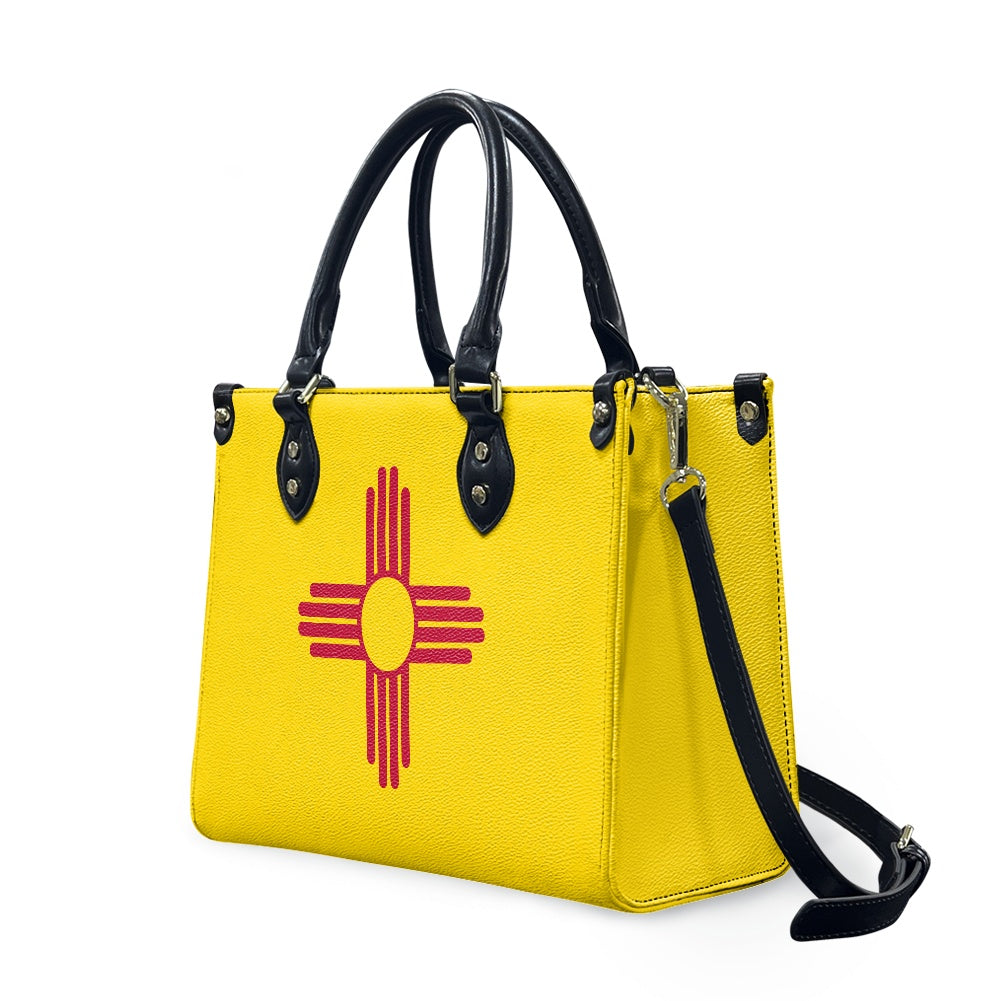 [Brand] yellow handbag with Zia symbol, black handles, strap.