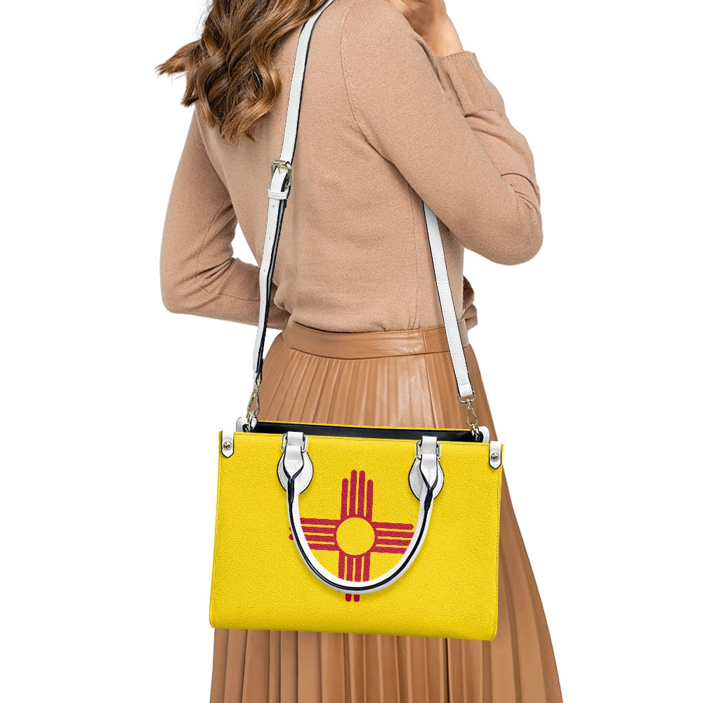 Woman with [Brand] yellow handbag featuring decorative emblem design.