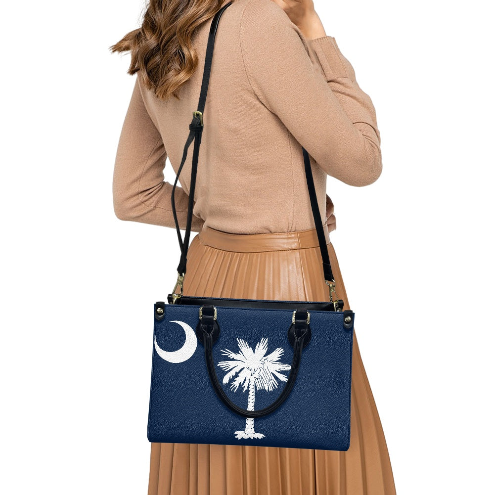 A woman carries navy [Brand] bag with palm design.
