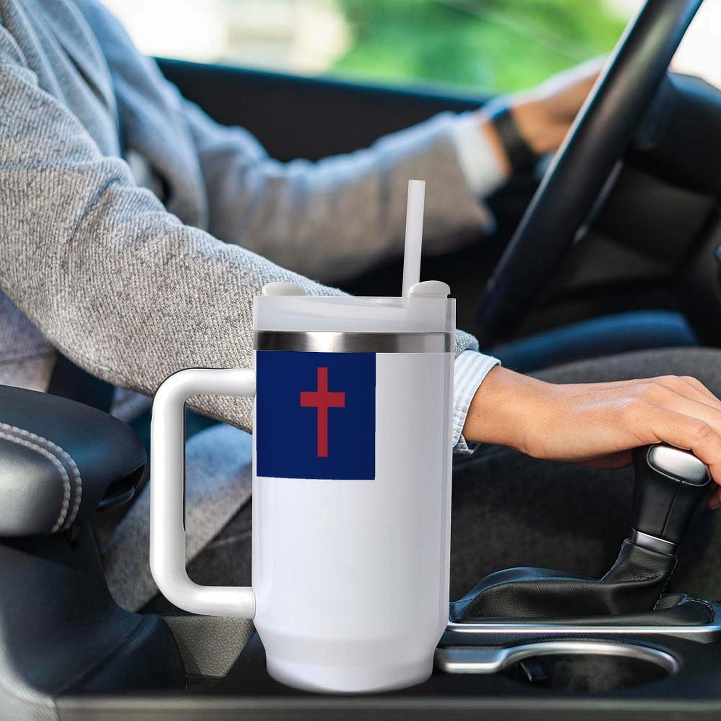 A person driving with a [Brand] mug in car.