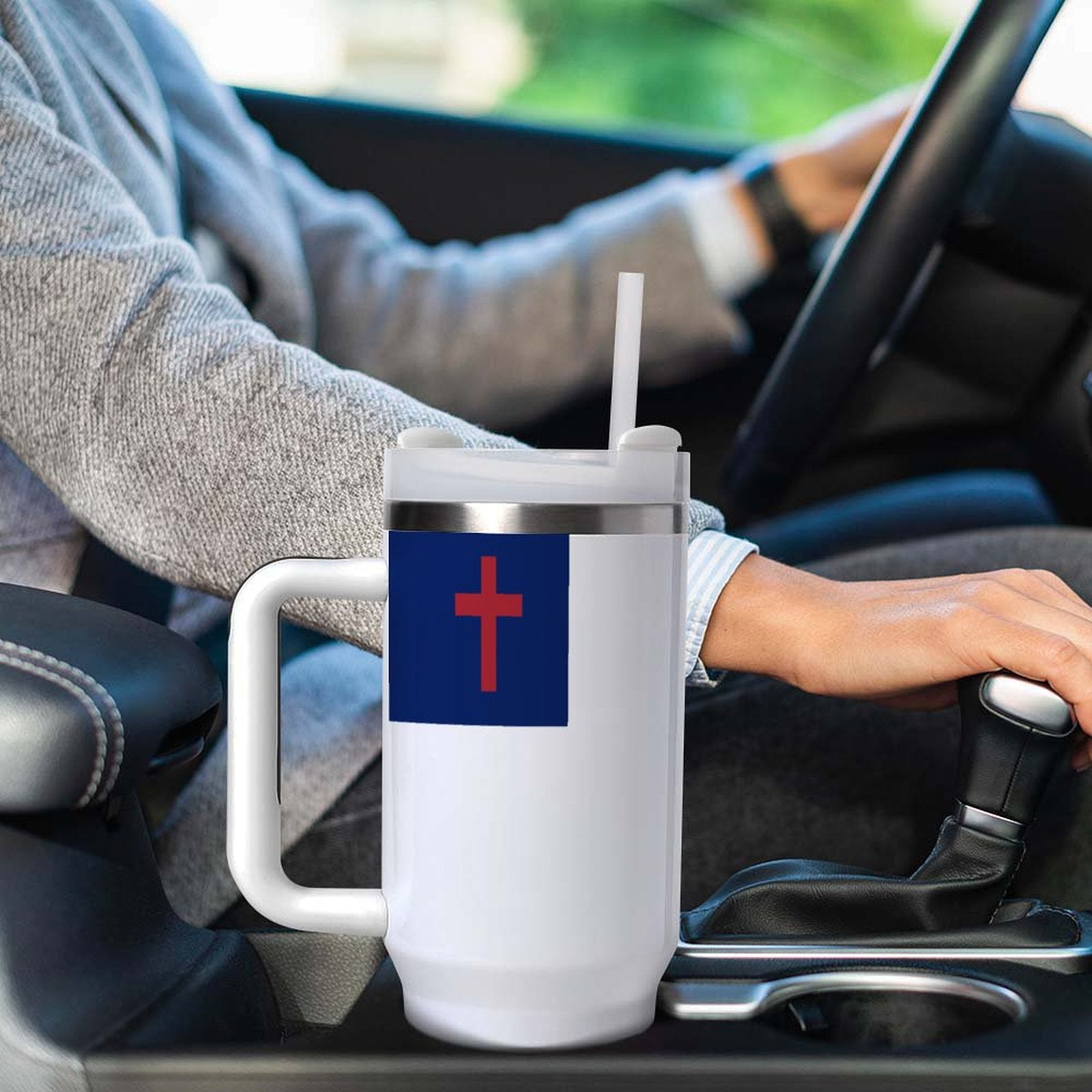 A person driving with a [Brand] mug in car.