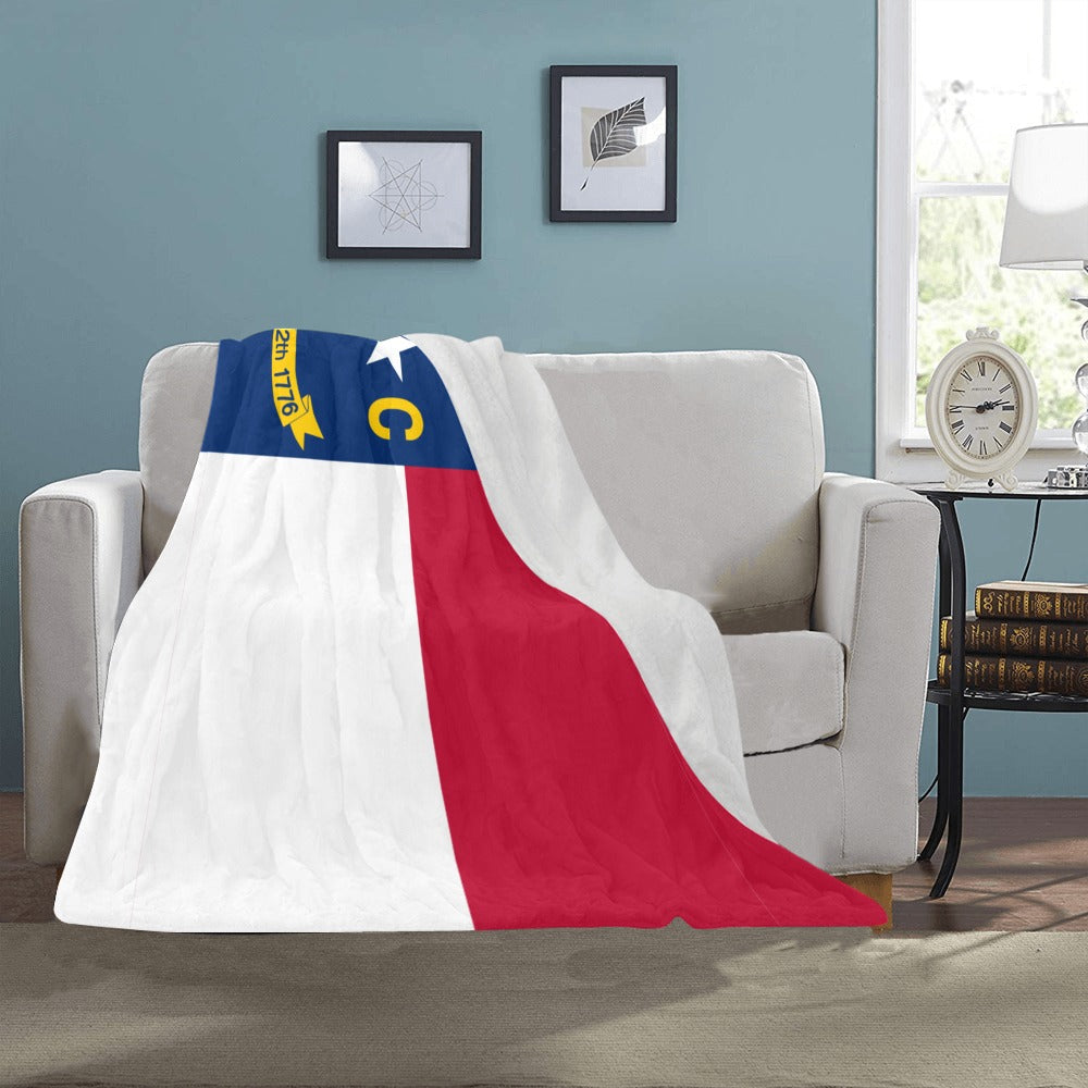 Cozy blanket on couch featuring North Carolina flag design. [Luv My Flag]