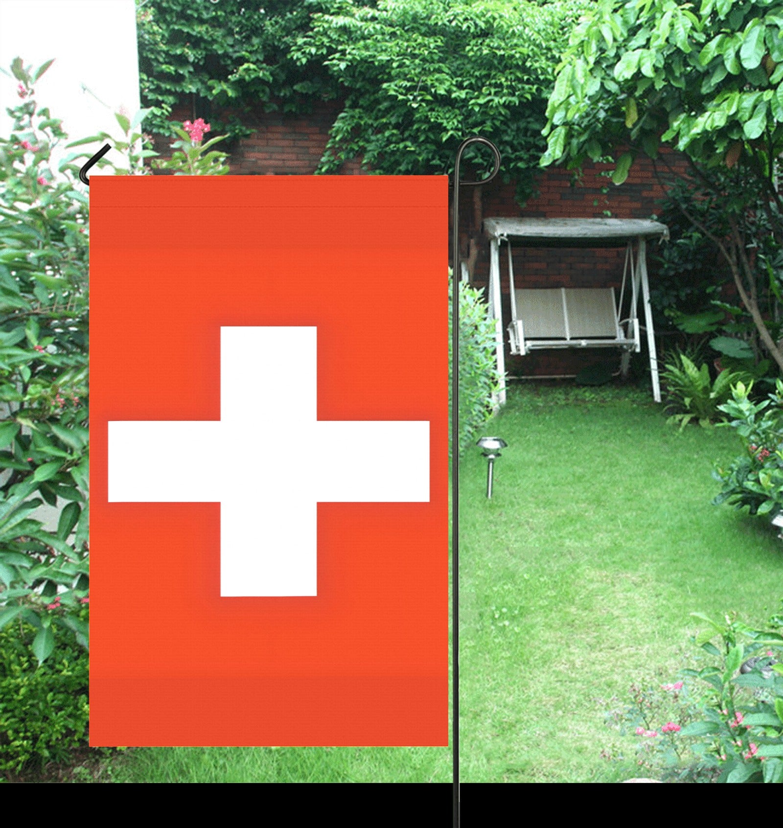 Luv My Flag: Swiss flag displayed in lush garden setting.