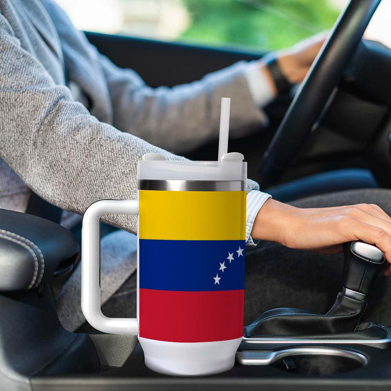 Person driving with [Brand] mug featuring Venezuelan flag design.