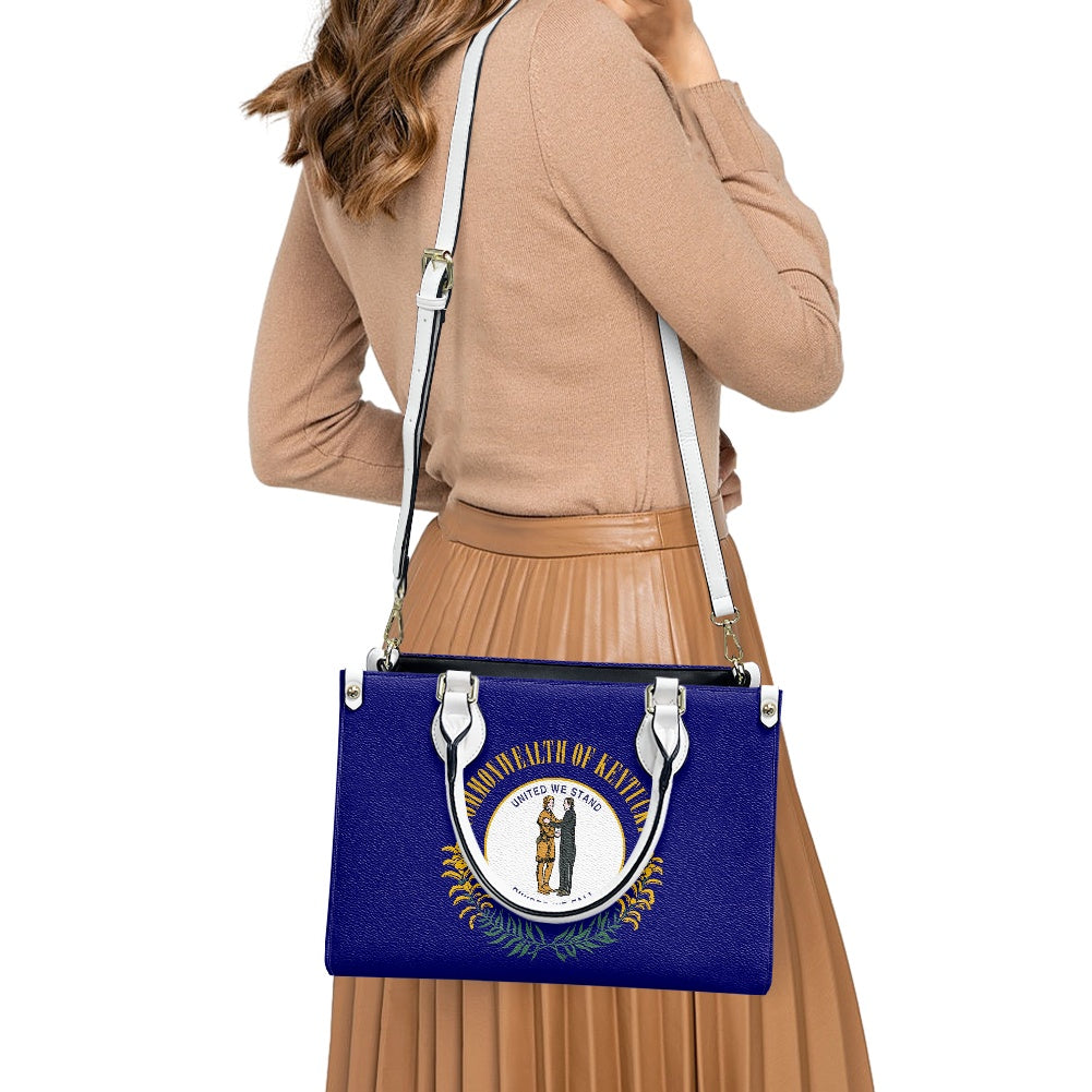 A woman holding [Brand] Kentucky flag-themed handbag stylishly.