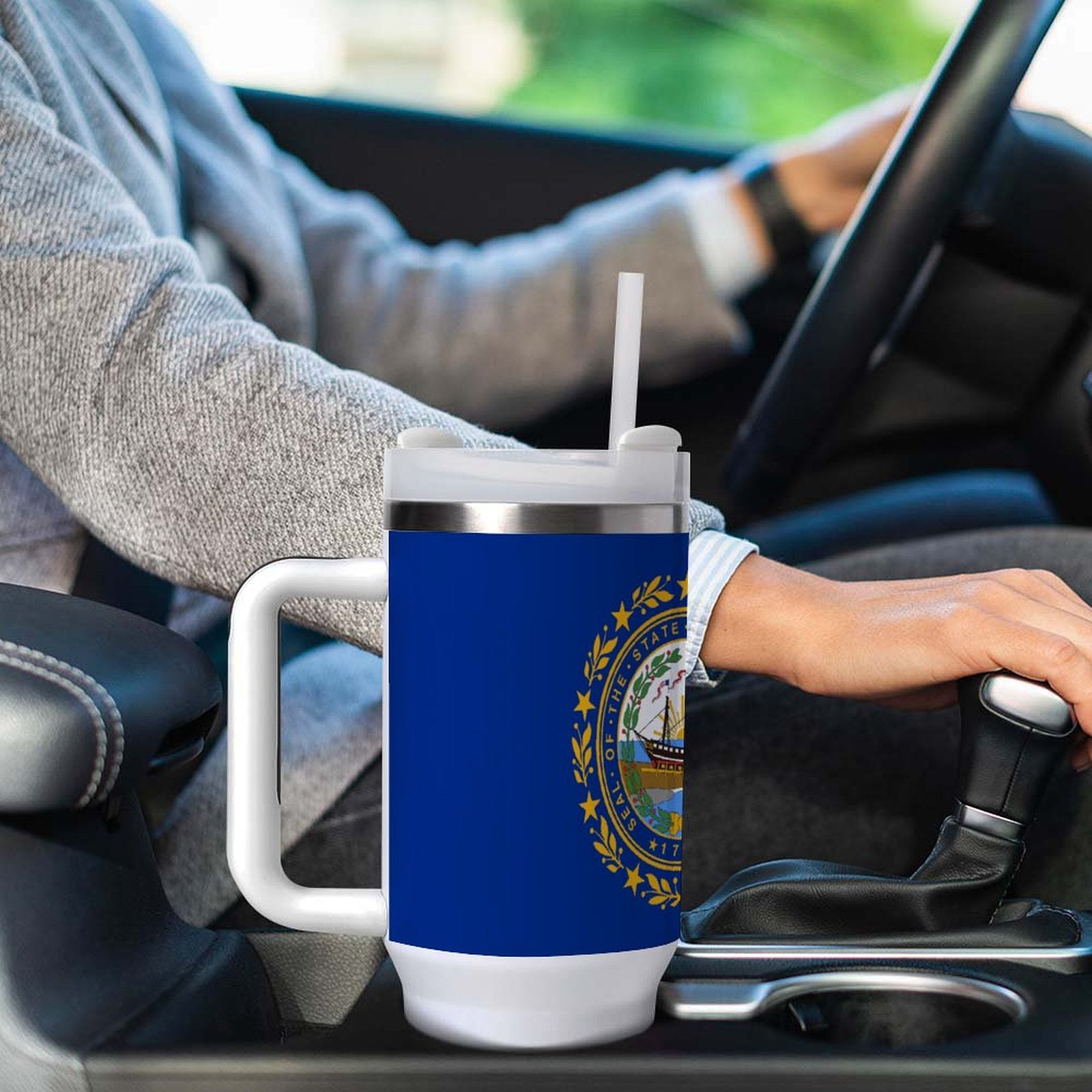 A [Brand] blue travel mug in car cup holder.
