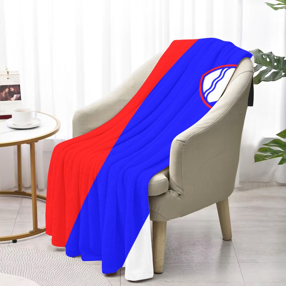 Red and blue [Luv My Flag] blanket on armchair, indoors.