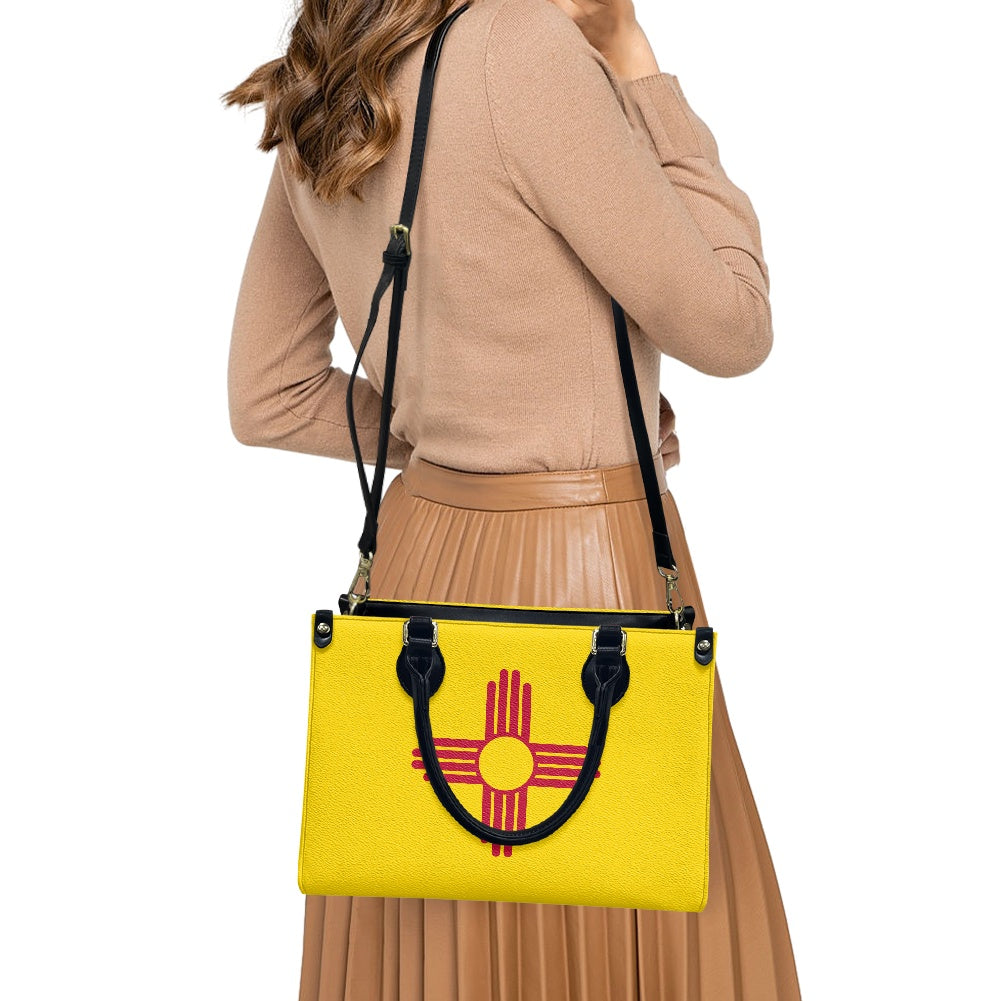 Woman carrying [Brand] yellow handbag with red sun symbol.